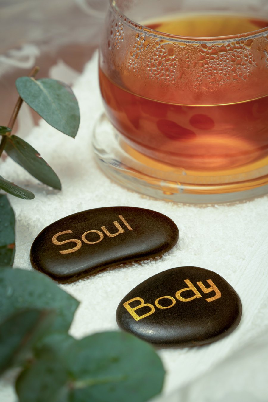 A cup of tea beside stones engraved with the words Soul and Body